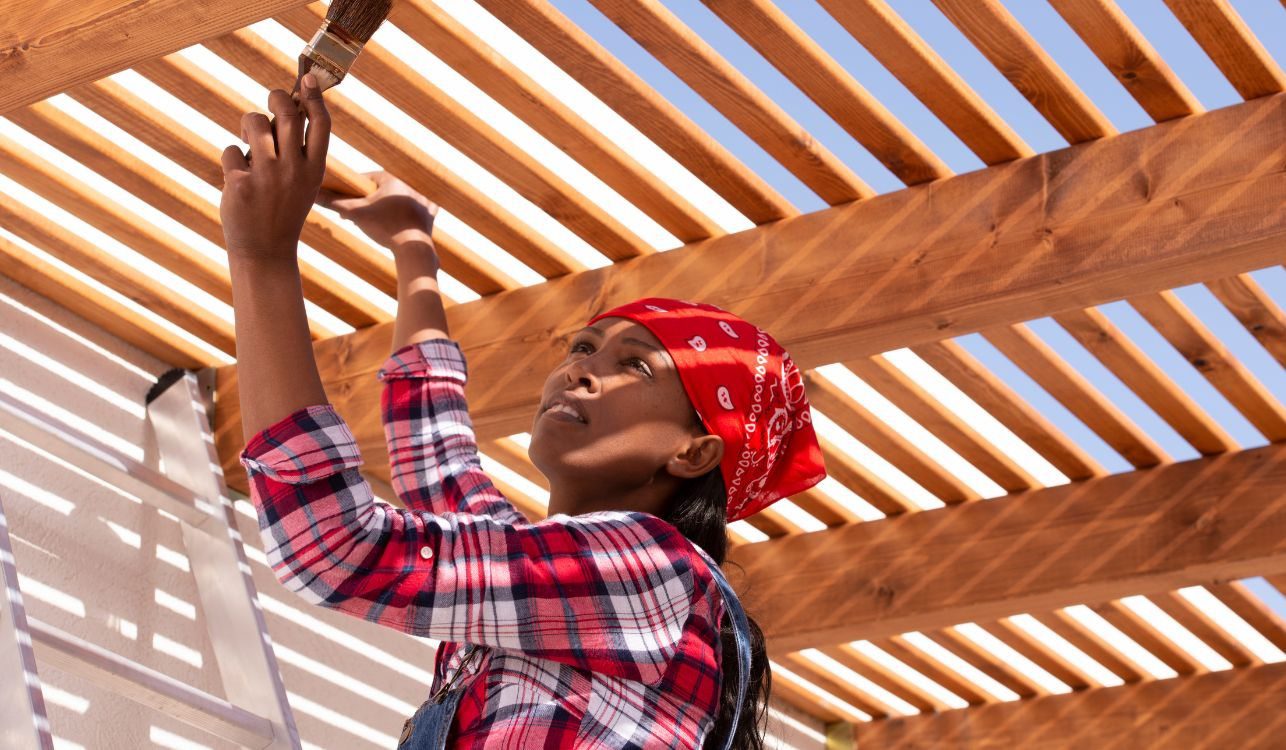 Moça pintando uma pérgola